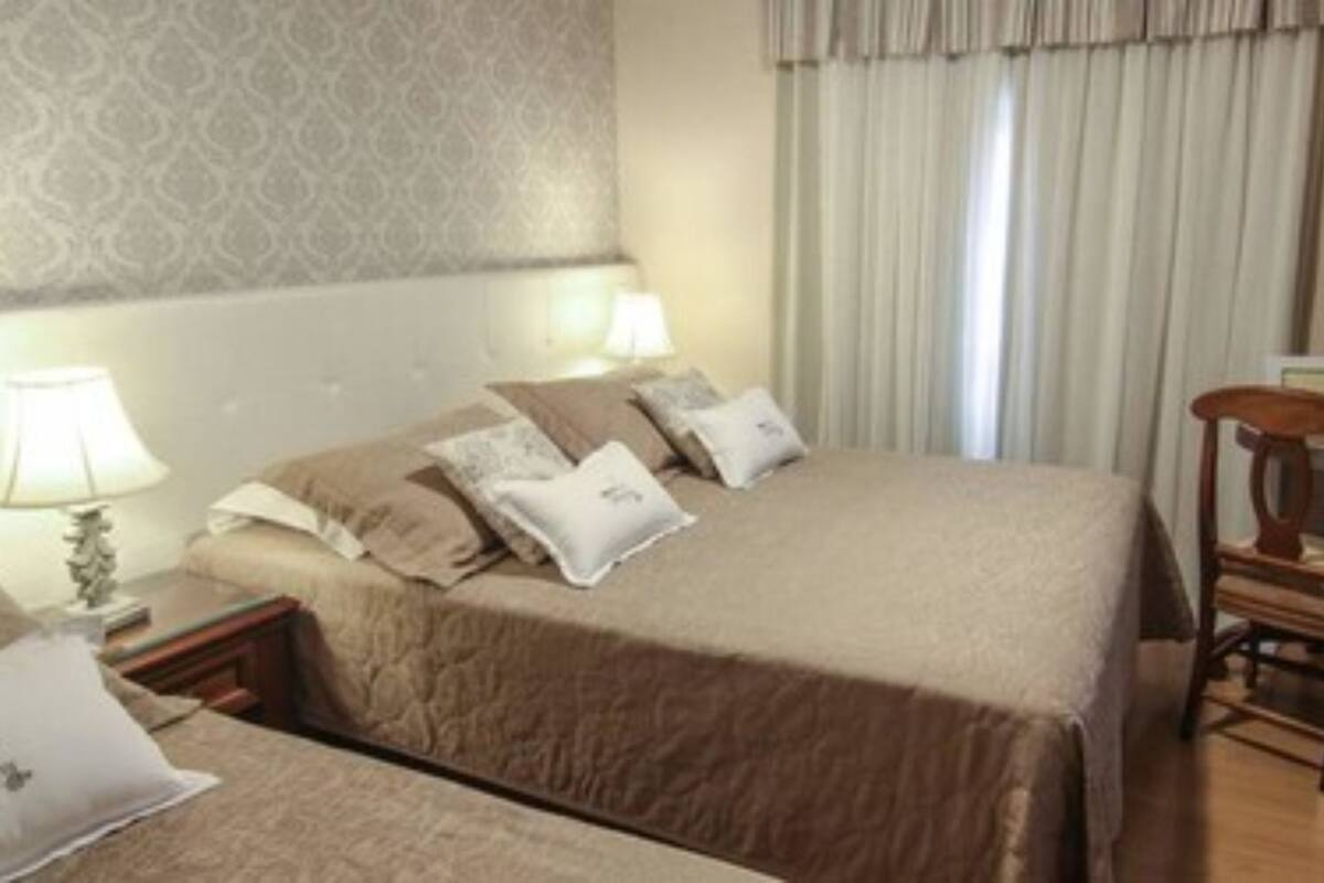 Une chambre d’hôtel avec deux lits, un bureau et une chaise.