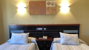 A double bed with a wooden headboard, two bedside tables, and a wall-mounted light fixture. - Hotel Sena (Caldas de Reis)