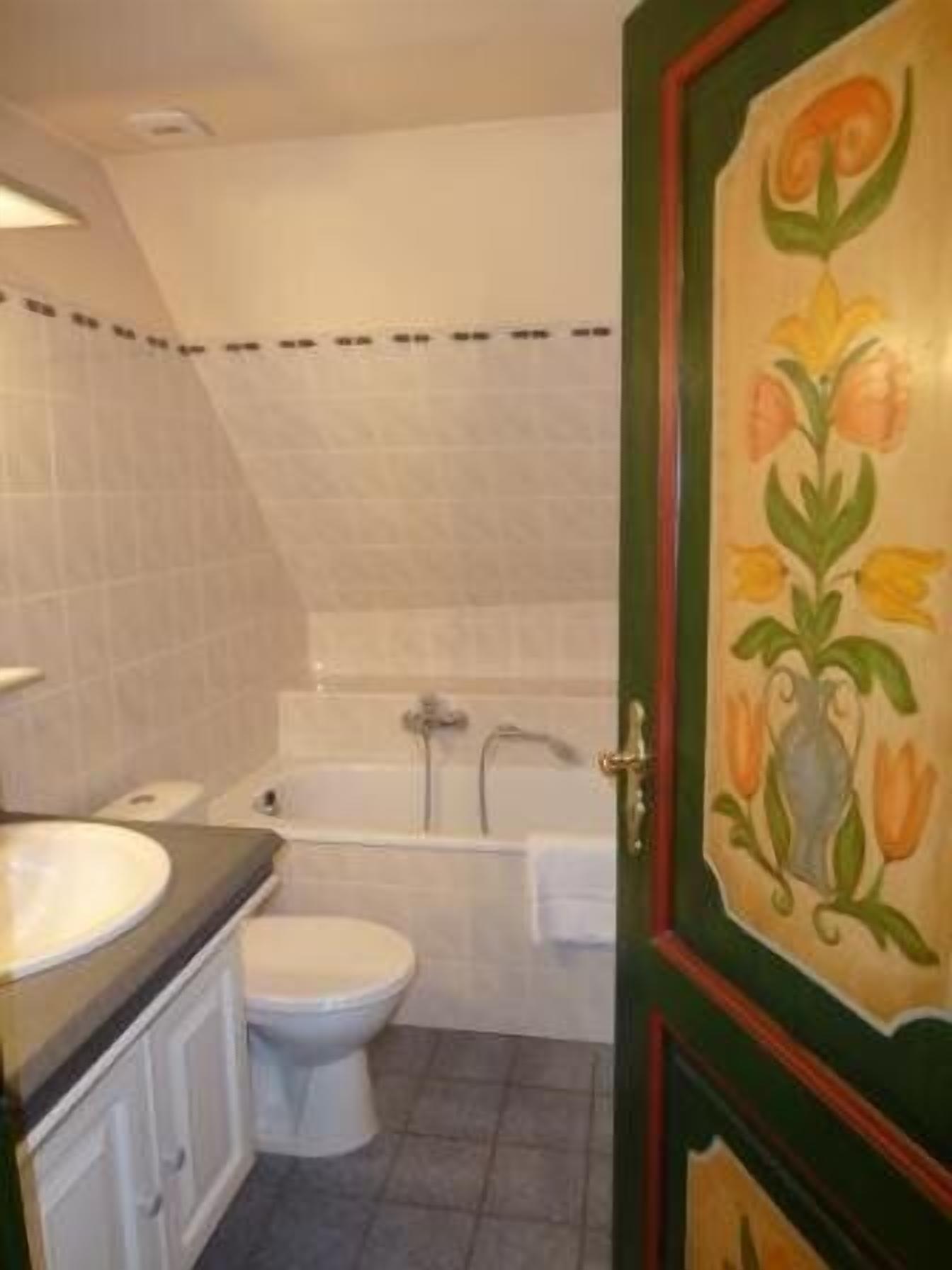 A bathroom with a toilet, sink, and bathtub.