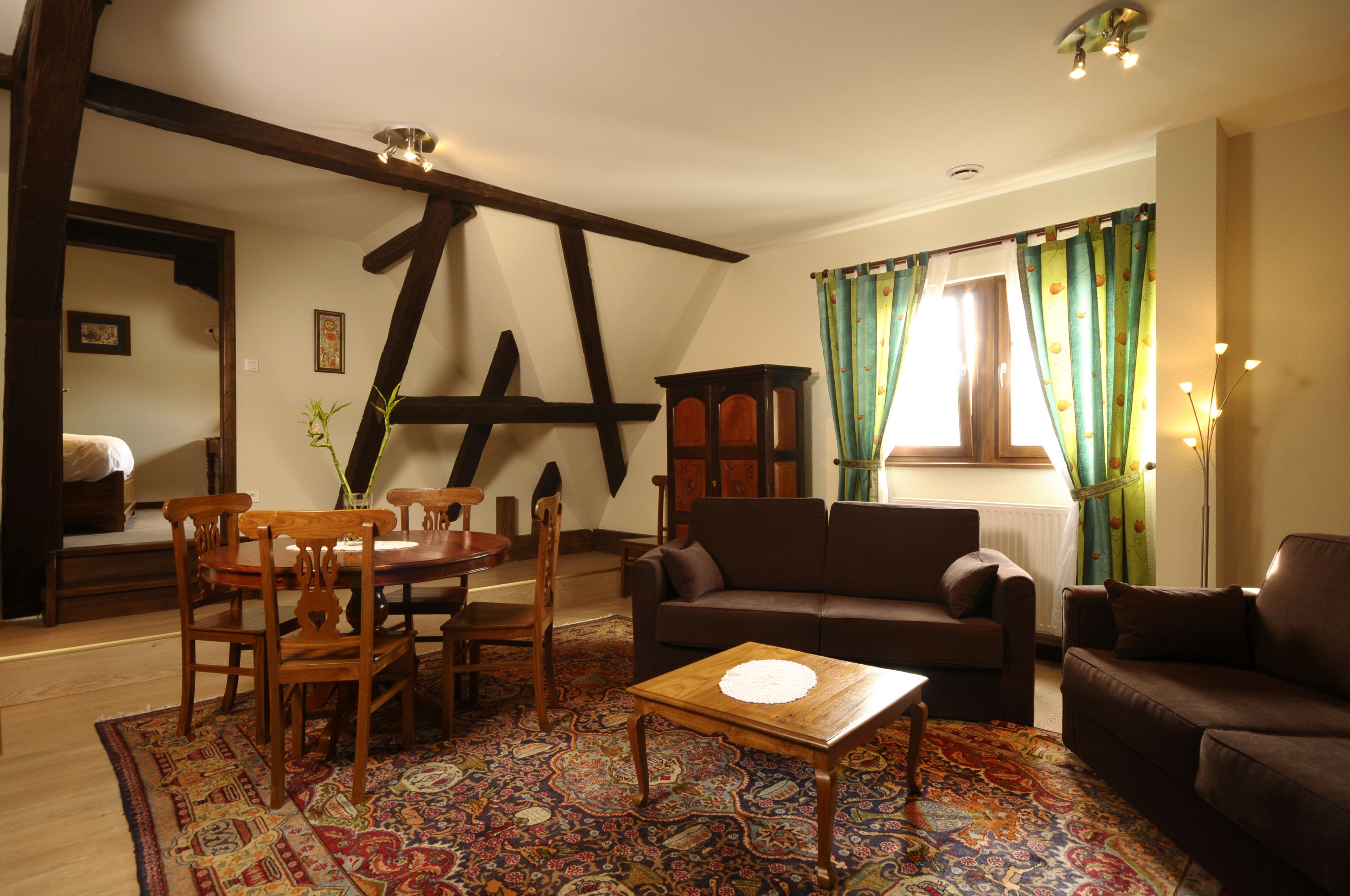 Una sala de estar acogedora con una mesa de comedor de madera, dos sofás y un tapete estampado.