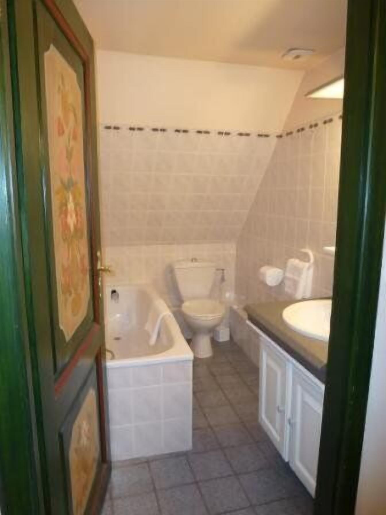 A bathroom with a toilet, bathtub, and sink.