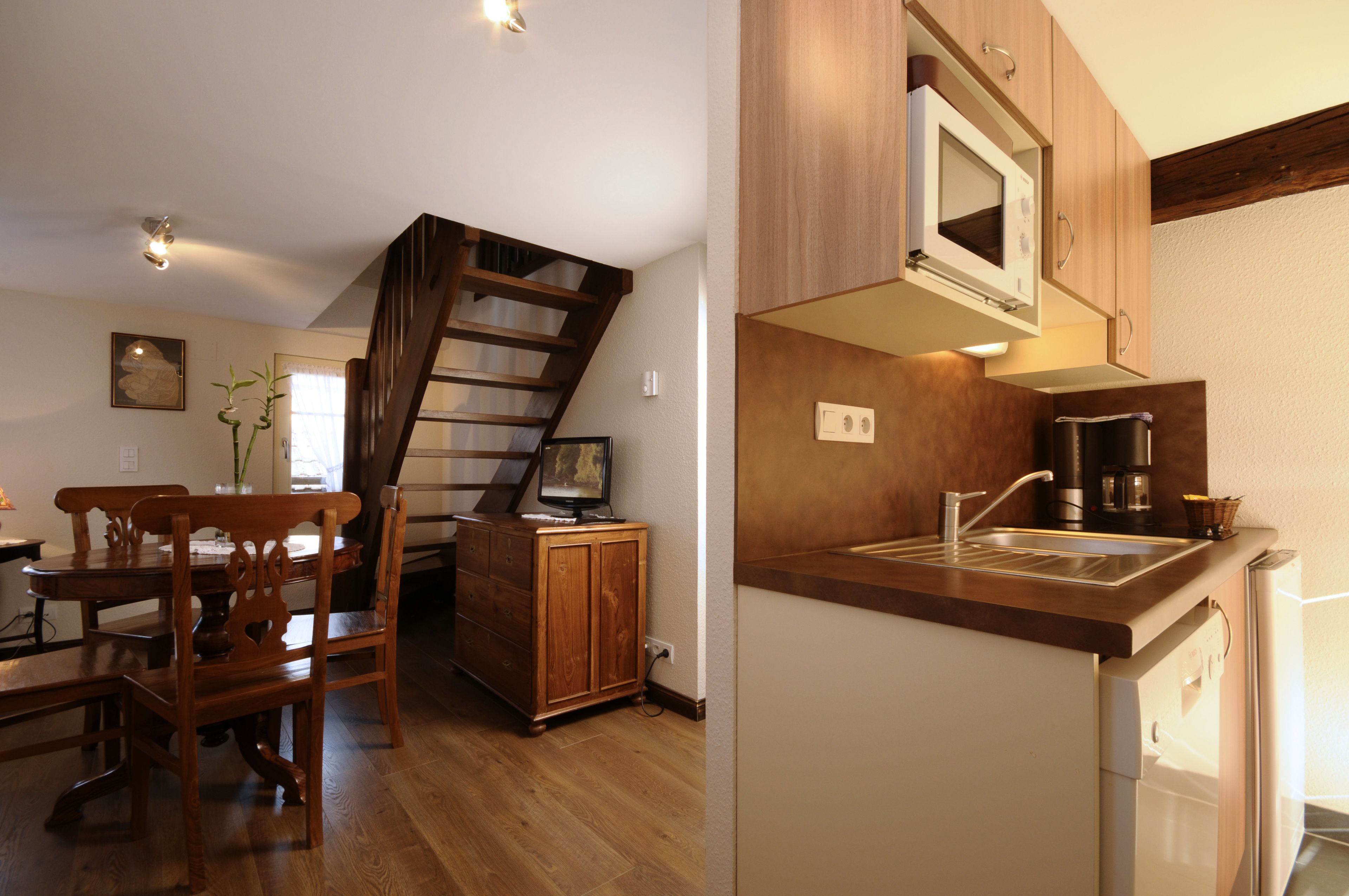 A kitchen with wooden cabinets, a built-in microwave, and a sink.