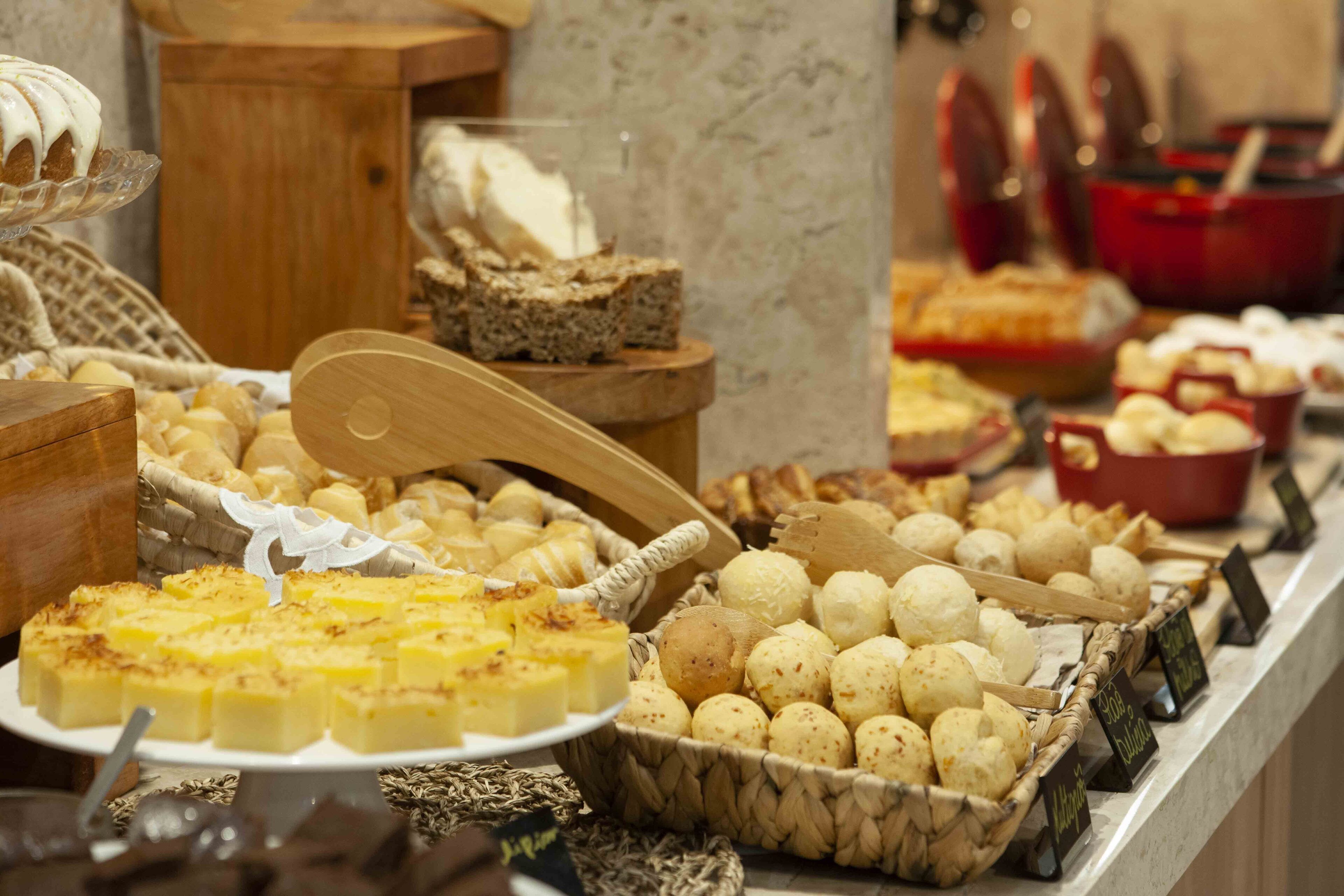 A buffet with various food items including bread, pastries, and cheese.