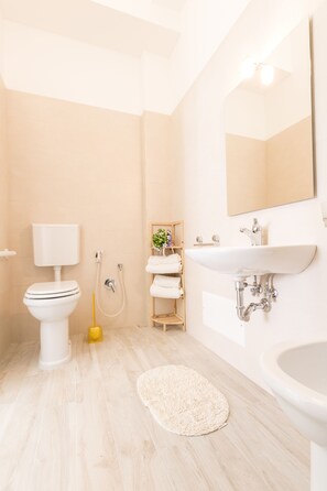 A modern bathroom with a toilet, sink, and shower. - La Gemma del Salento (Racale)