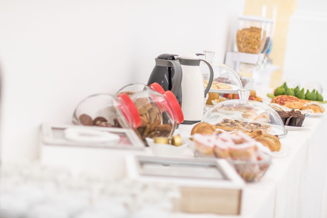 Un tavolo per buffet con diversi cibi e un angolo caffè.