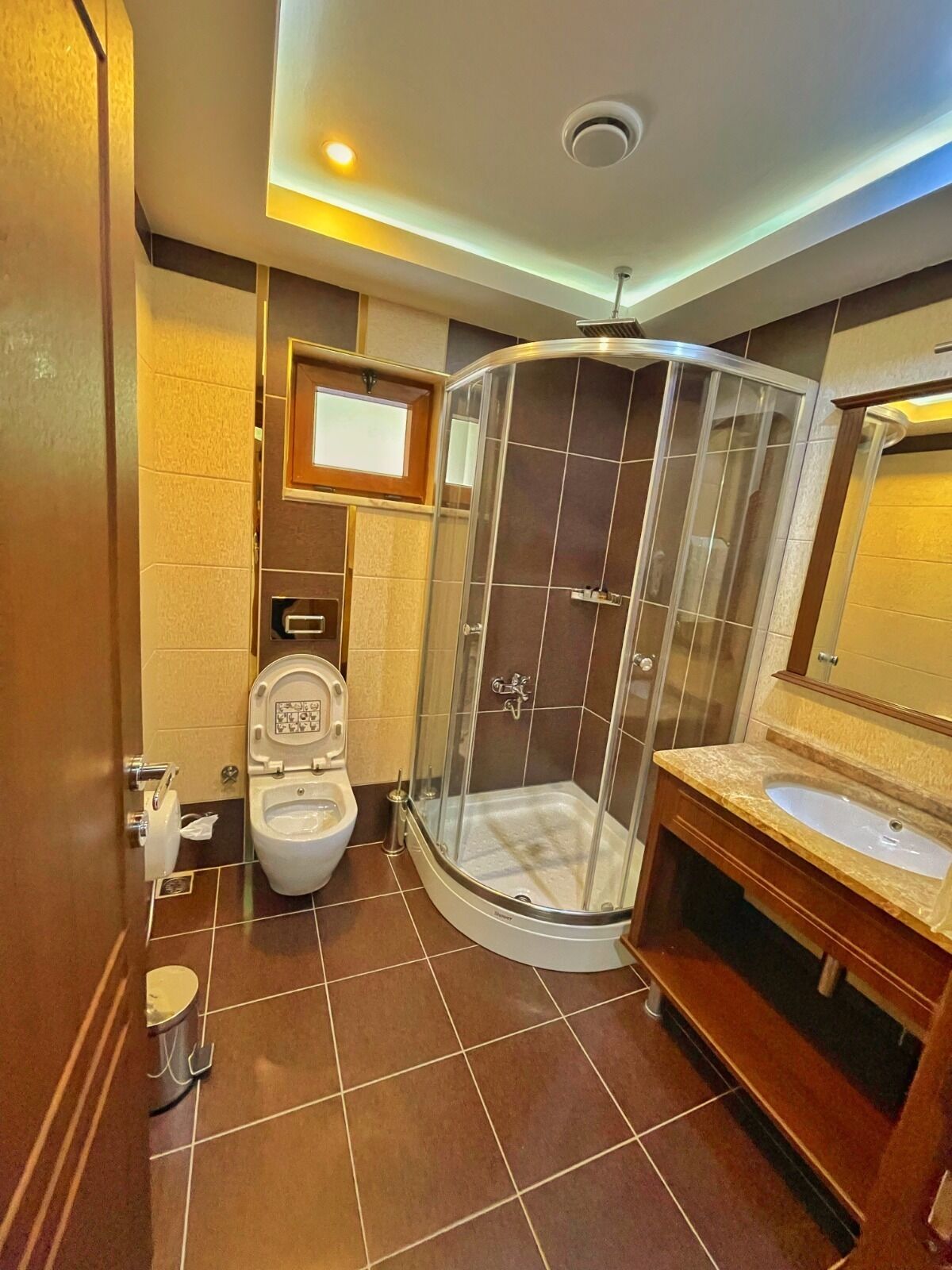 Ein modernes Badezimmer mit einer Duschkabine, einer Toilette und einem Waschbecken mit Waschtisch.