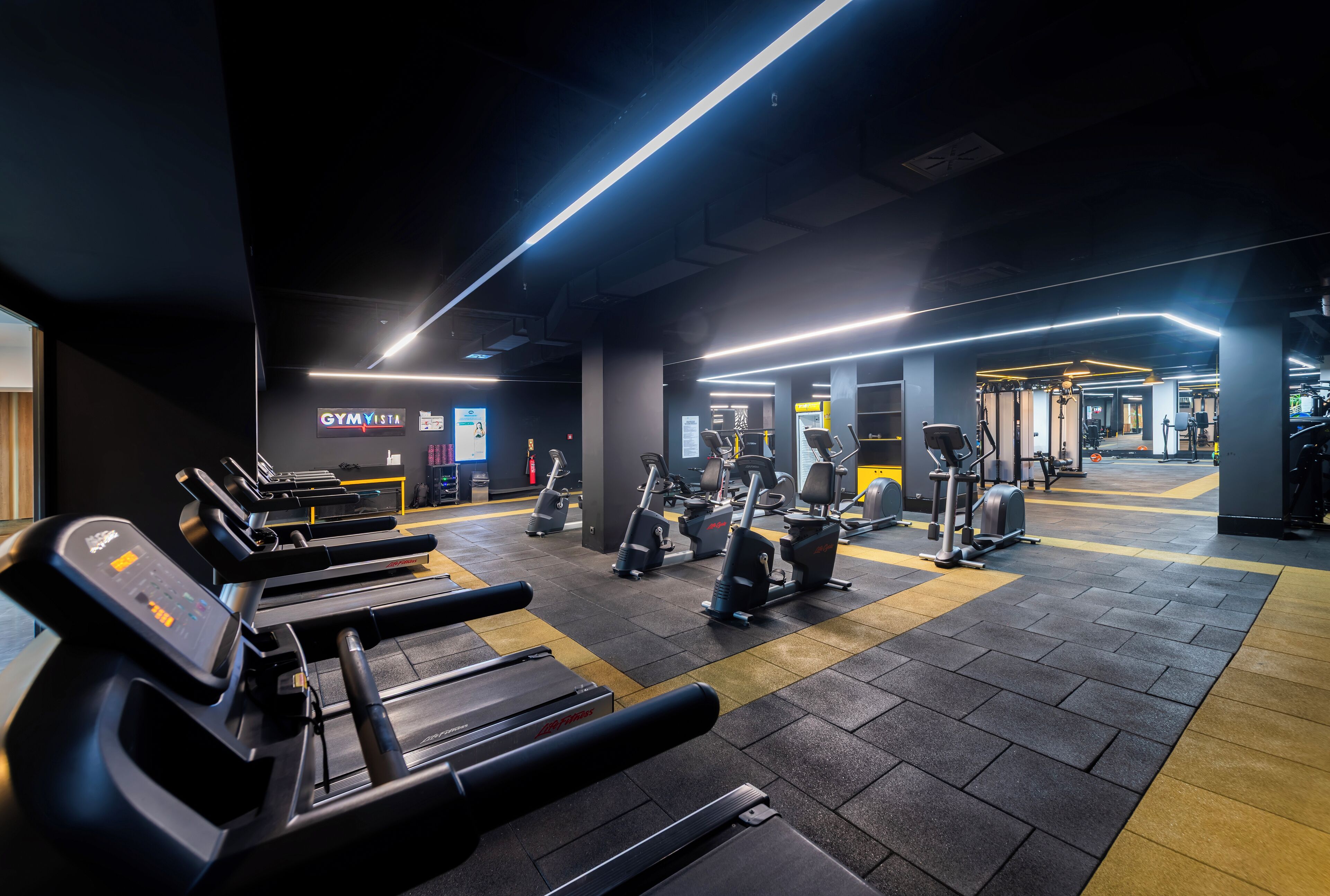 A gym with treadmills, stationary bikes, and weight machines.