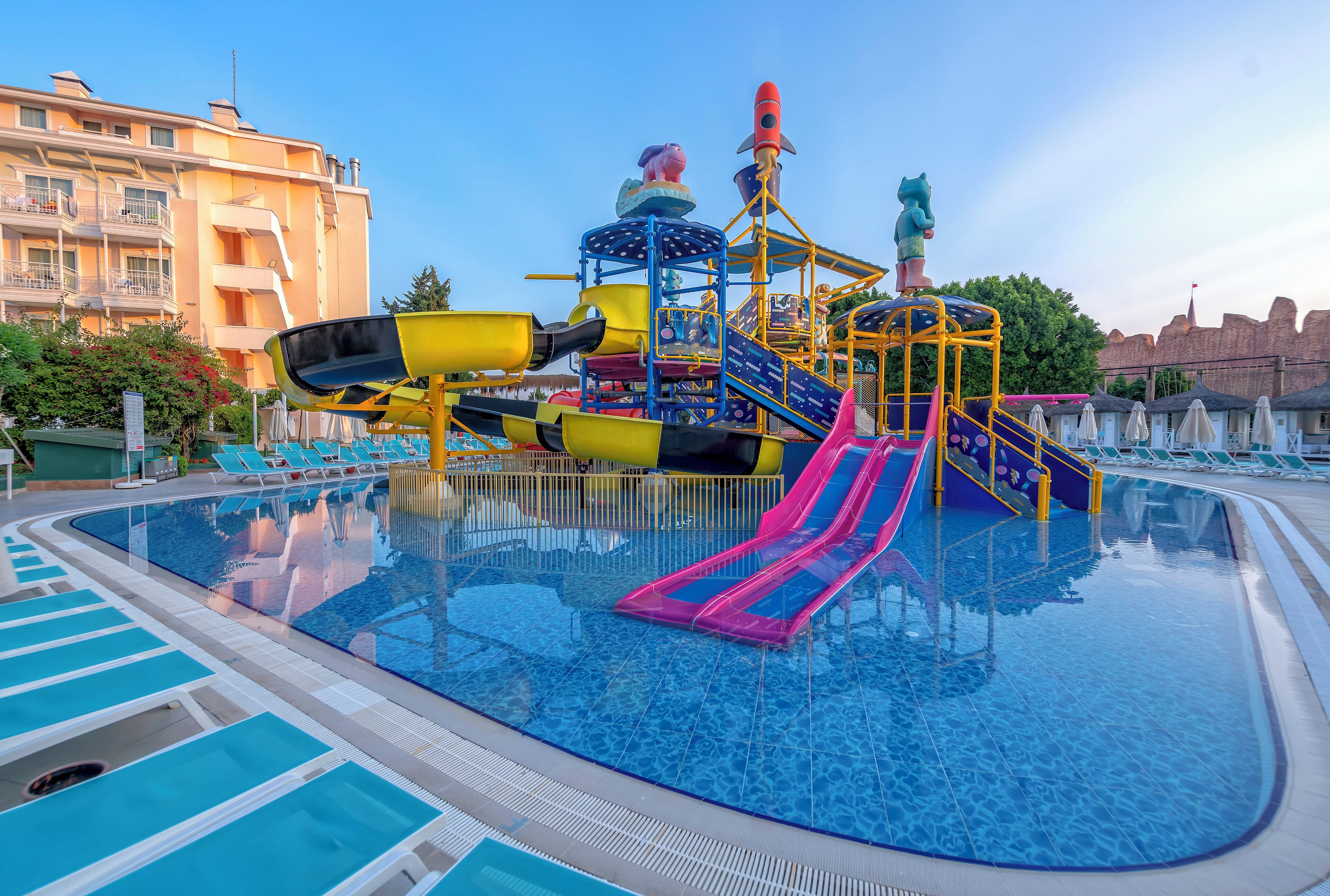 A swimming pool with slides and a play structure.