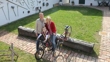 Un patio con sendero de ladrillo, un banco de madera y una bicicleta.