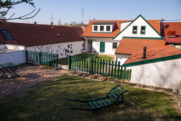 A residential area with a white house, red-tiled roof, and a green fence. - Winzerhof Küssler, Weinviertel (Angern an der March)