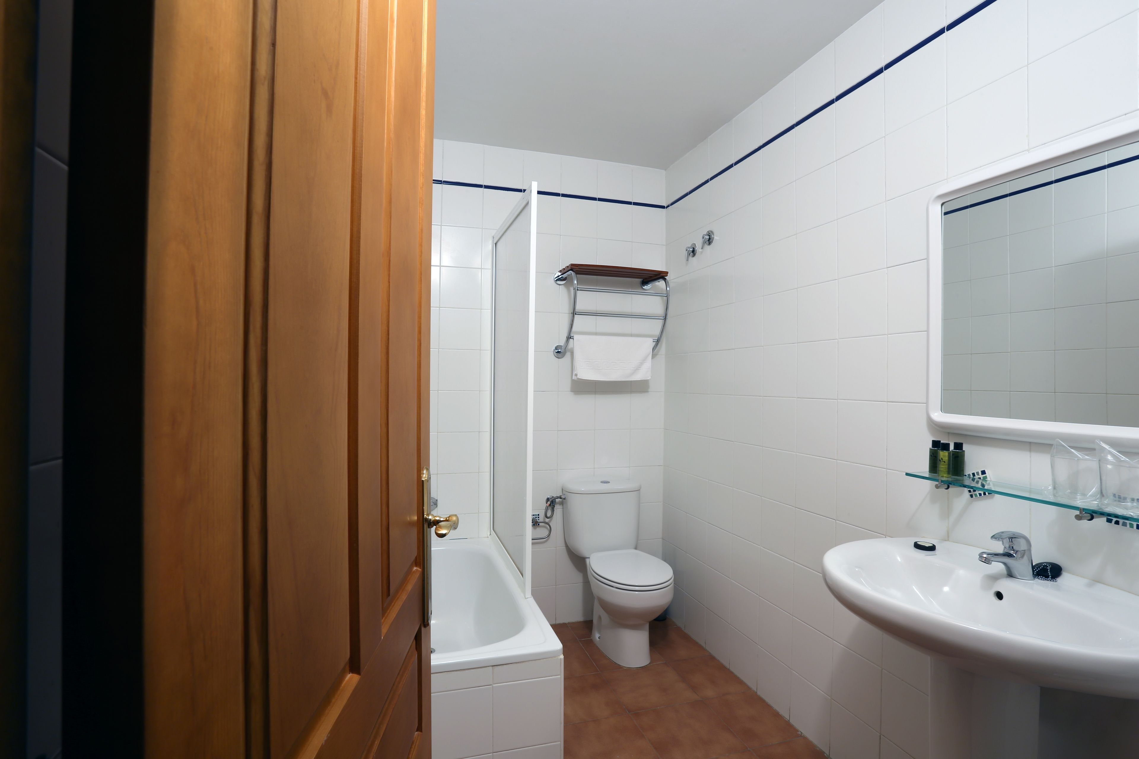 A bathroom with a bathtub, toilet, and sink.