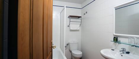 A bathroom with a bathtub, toilet, and sink.