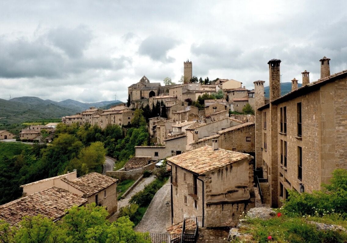 Un pueblo histórico con arquitectura medieval, que incluye una iglesia destacada y edificios de piedra.