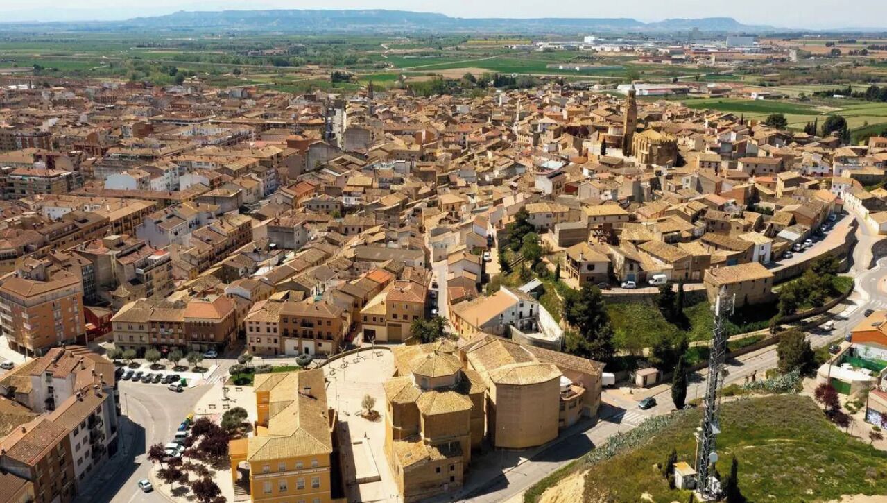 Vista aérea de una zona urbana densamente poblada con numerosos edificios, calles y una imponente estructura en forma de torre.
