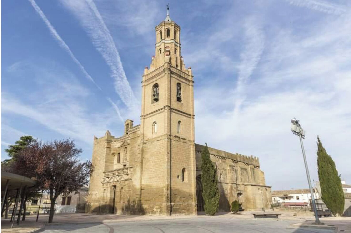 A historic stone building with a prominent bell tower, likely a church or cathedral, featuring arched windows and a symmetrical facade.