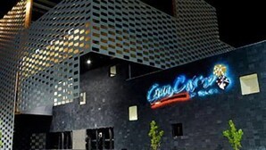 Ein modernes Gebäude mit einer markanten, geometrischen Fassade und einem gut sichtbaren Schild mit der Aufschrift 'Coca-Cola'.