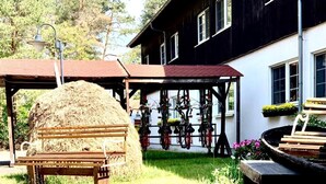 A rustic outdoor area with a hay bale, bicycles, and a wooden bench. - Spree-Waldhotel Cottbus (Cottbus)