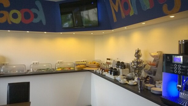 Un buffet pour le petit-déjeuner proposant divers aliments et une machine à café.