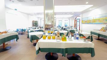 Enjoy breakfast in a spacious dining area with tables set for a meal.