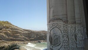 A coastal view with rocky cliffs and waves. - Hotel Sablón (Llanes)
