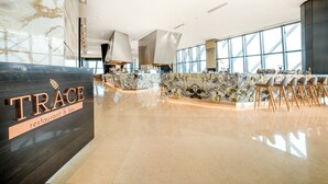 A modern restaurant interior with a marble reception desk, large windows, and a bar area. - Element by Marriott Kuala Lumpur (Kuala Lumpur)