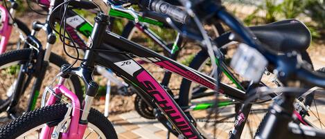 A row of bicycles parked outdoors, with visible brand names and model numbers.
