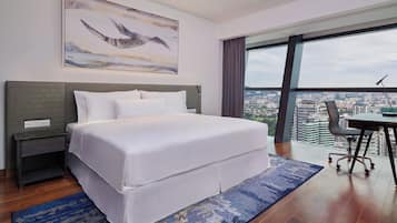 Una habitación de hotel moderna con una cama grande, un escritorio y vistas a la ciudad.