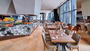 A modern restaurant with a marble counter, wooden tables, and chairs. - Element by Marriott Kuala Lumpur (Kuala Lumpur)