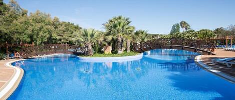 Una piscina al aire libre de temporada, sillones reclinables de piscina
