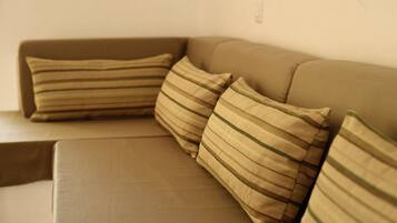 En beige soffa med randiga kuddar.