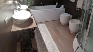 A bathroom with a sink, mirror, bathtub, toilet, and shower. - B&B La Bella Lucca (Lucca)