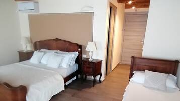 Une chambre d’hôtel avec deux lits en bois, un plafond en bois et un grand miroir au mur.