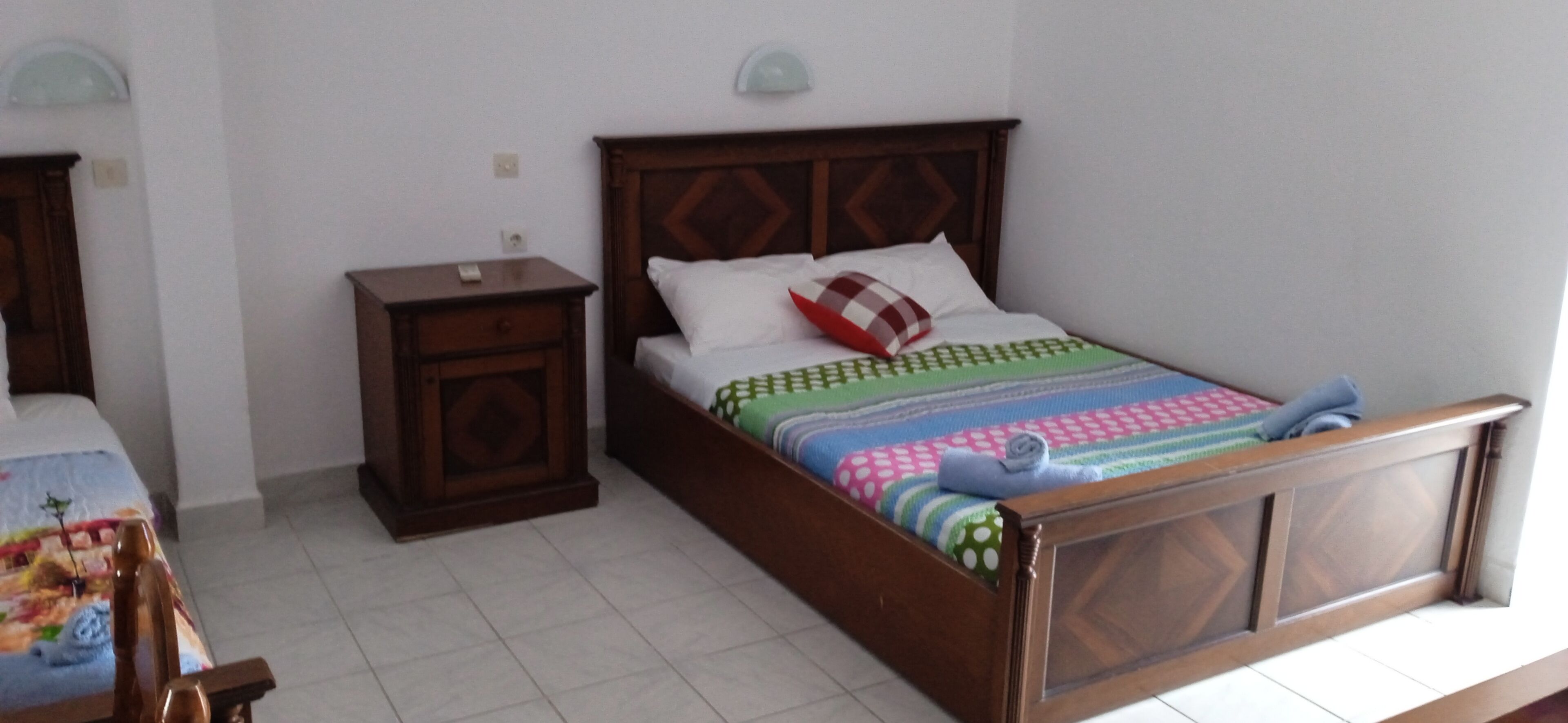 Ein Schlafzimmer mit einem hölzernen Bett, einem Nachttisch und einem Beistelltisch.