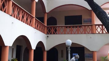 A multi-level courtyard with arches, a statue, and potted plants.