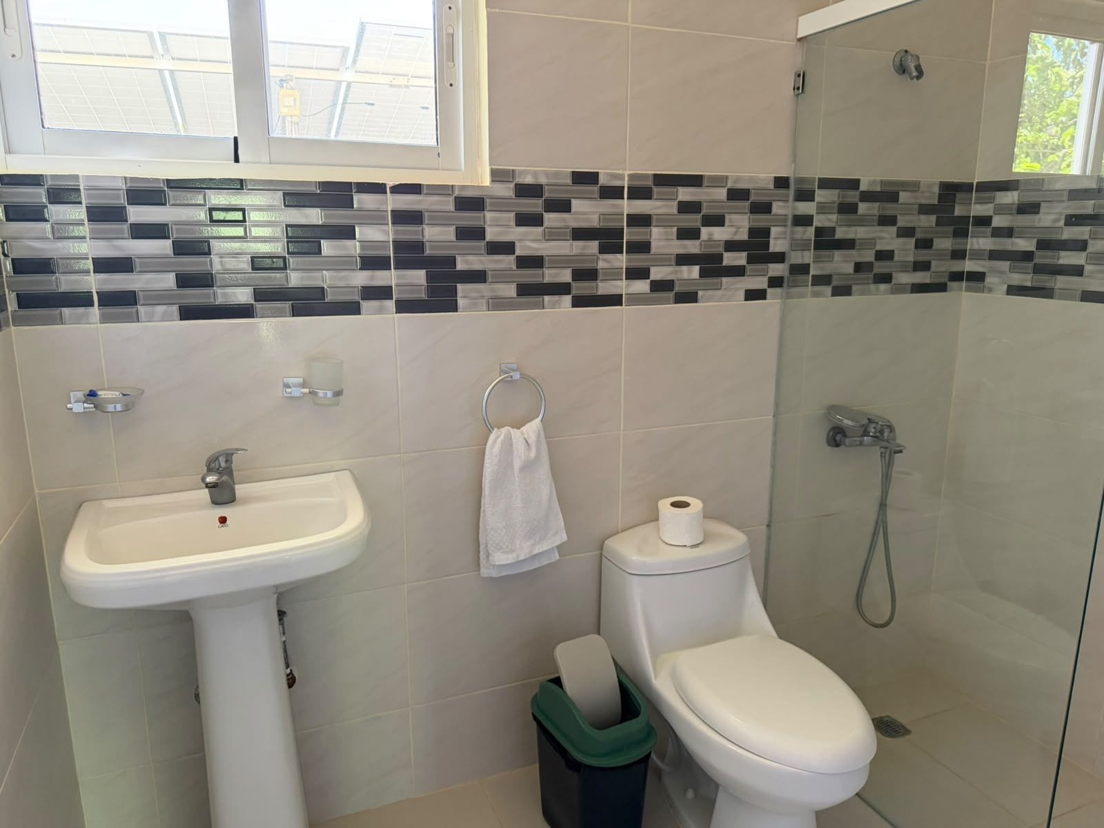 Een badkamer met een wastafel, toilet en douche.