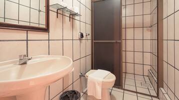 Une salle de bain avec un lavabo, des toilettes et une douche.
