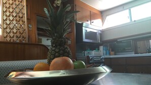 Eine Küche mit Holzausstattung, einer Mikrowelle und einer Obstschale auf der Arbeitsfläche.