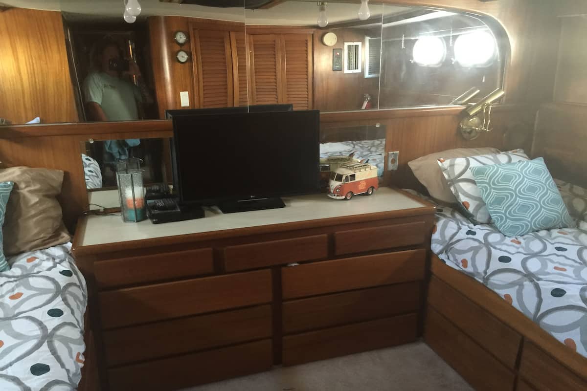 A compact living space with a wooden entertainment unit, a television, and a toy van.