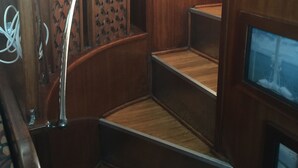 Eine Holzt Treppe mit Metallgeländern und einer Wand mit Muster.