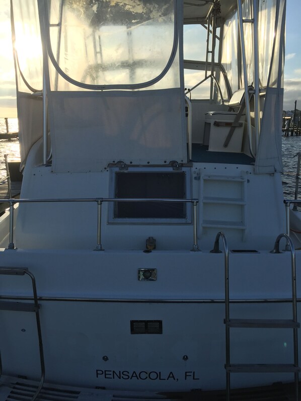 A boat named 'PENSACOLA, FL' with a cabin, a small window, and a ladder.