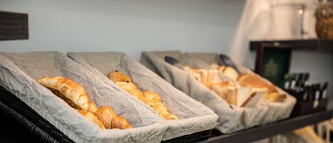 A bakery display with croissants and other pastries in baskets.