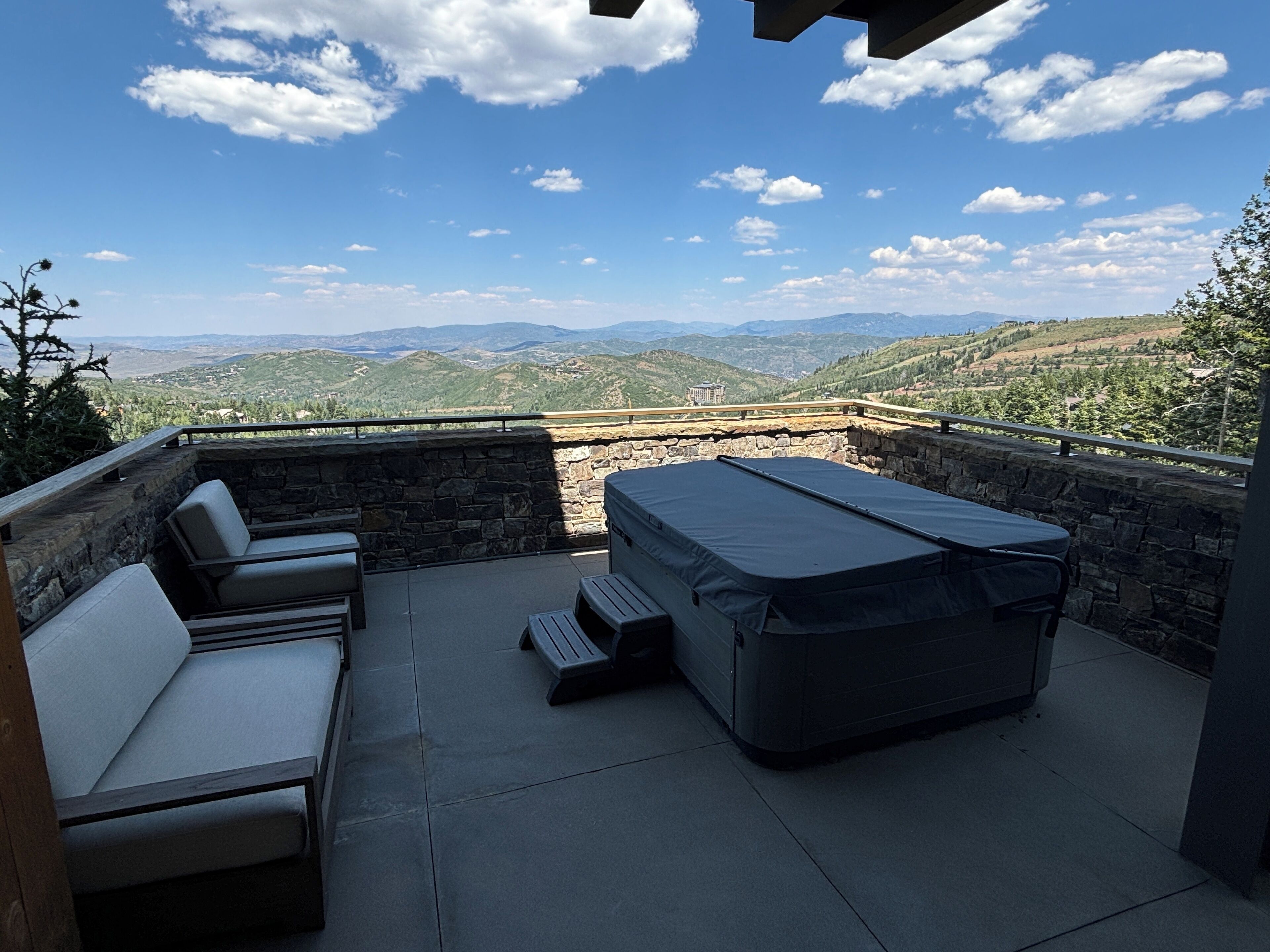 A patio with outdoor seating and a view of distant mountains.