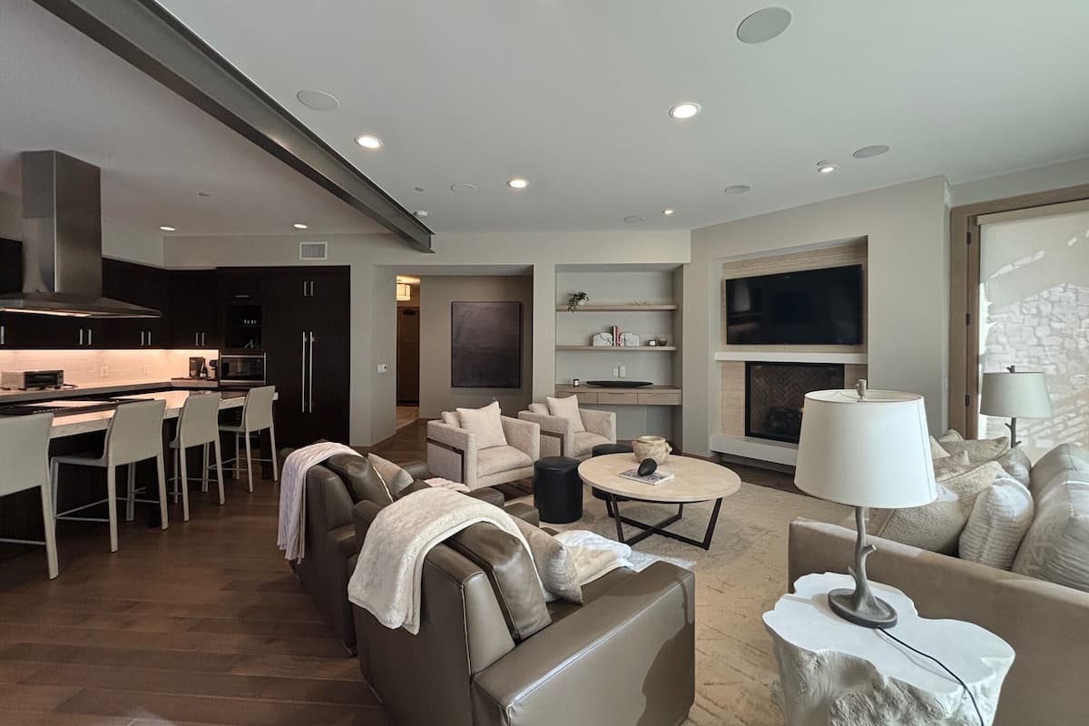 Un salon moderne comprenant un canapé, des fauteuils, une table basse, un téléviseur et une cheminée.