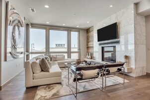 A modern living room with a sofa, coffee table, and a fireplace.