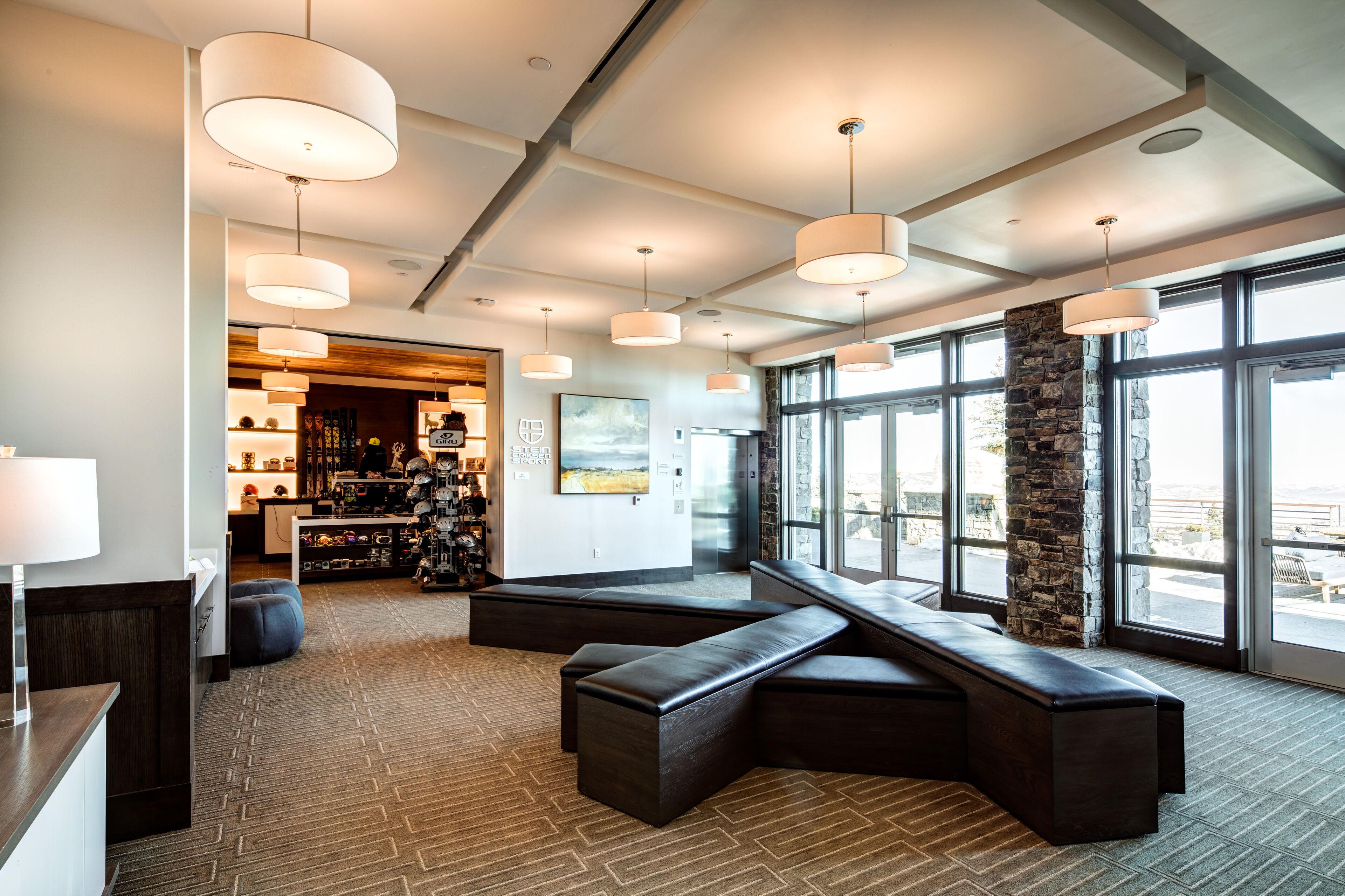A modern interior with a seating area, large windows, and a bar.