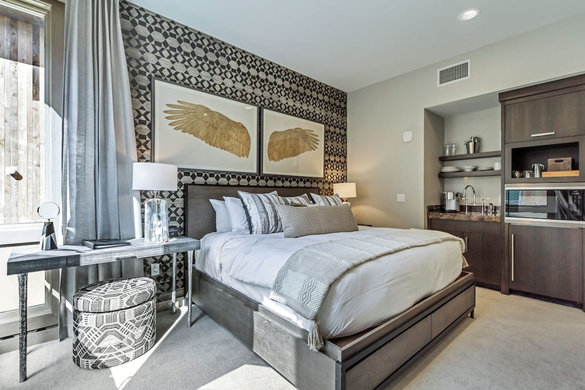 Une chambre à coucher moderne avec un grand lit, un bureau et une armoire.