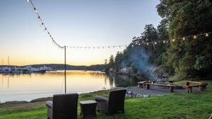 A serene lakeside setting with string lights, wicker chairs, and a fire pit area. - Roche Harbor Resort (Friday Harbor)