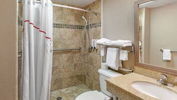 A bathroom with a shower, toilet, and sink.