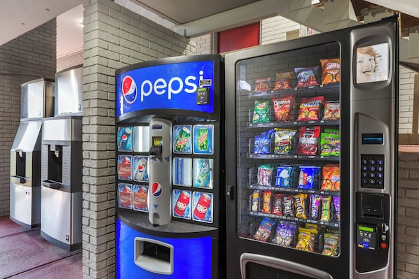 Máquina expendedora con el logotipo de Pepsi y una variedad de aperitivos y bebidas.