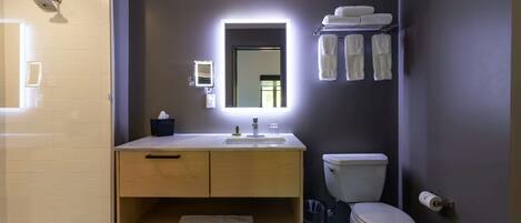 Un baño moderno con inodoro, lavabo y ducha.